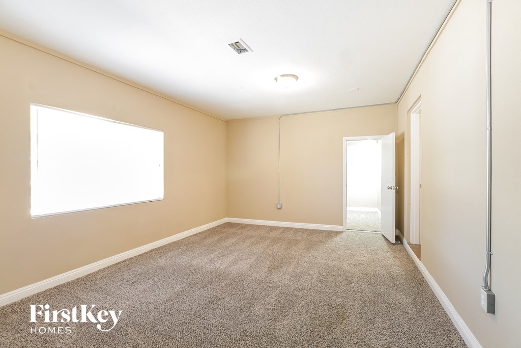 a empty room with a carpeted floor and a window