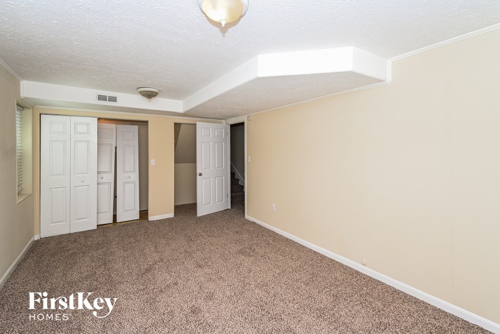 a bedroom with a carpeted floor and a door to a closet