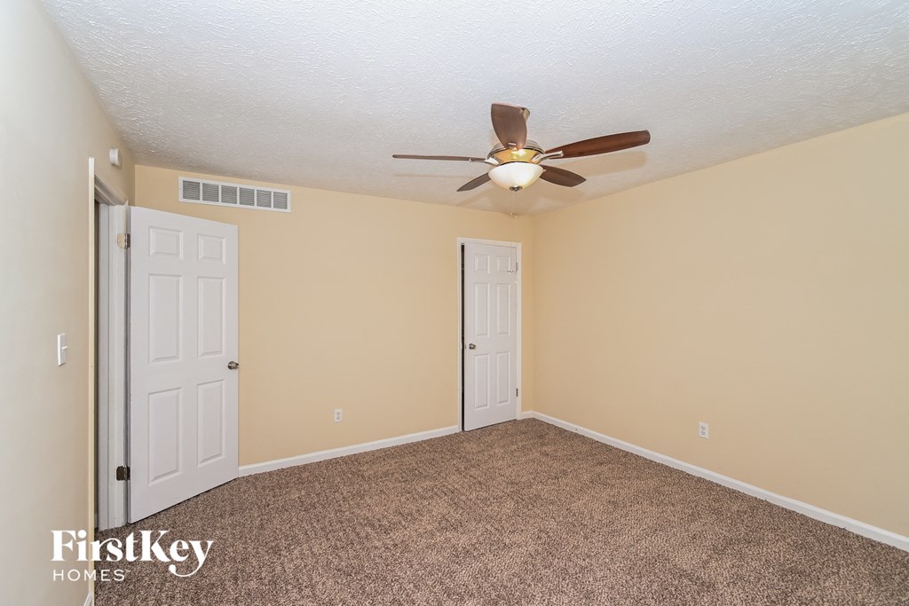 a bedroom with a ceiling fan and a closet
