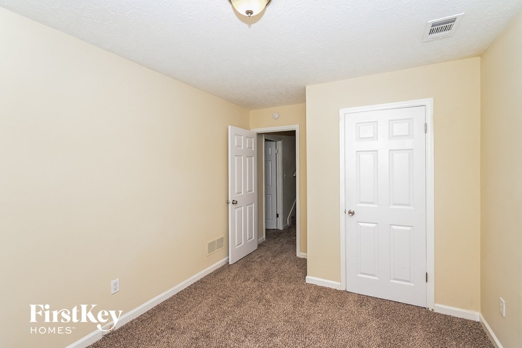 a bedroom with two white doors and a carpeted floor