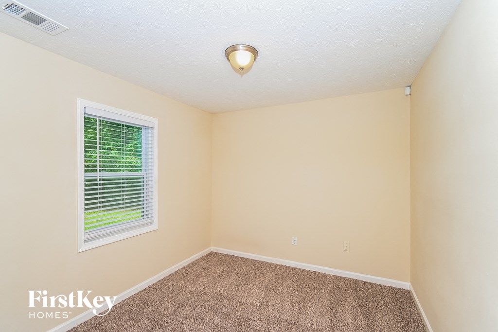 an empty room with a window and a carpet