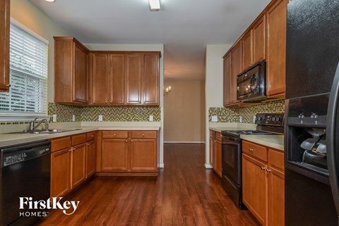 A kitchen with wooden cabinets and black appliances.