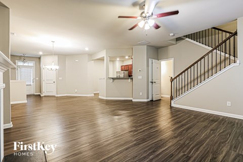 A spacious living room with a staircase leading to the upper floor.