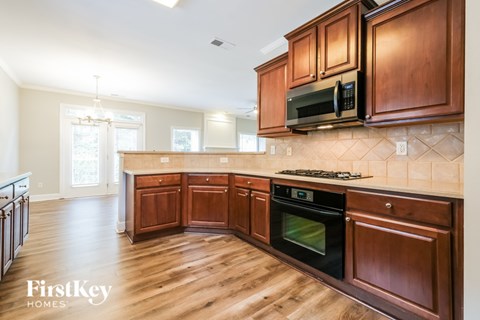 A kitchen with wooden cabinets and a black oven.
