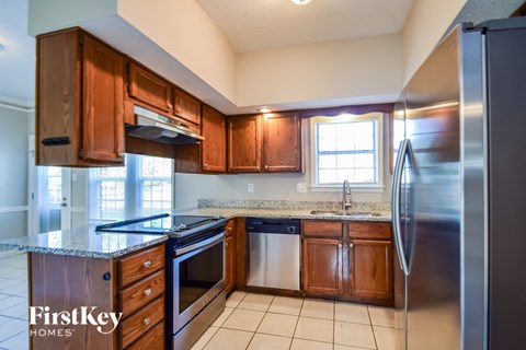 A kitchen with wooden cabinets and a granite countertop.