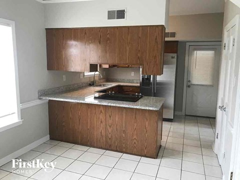 A kitchen with wooden cabinets and a granite countertop.