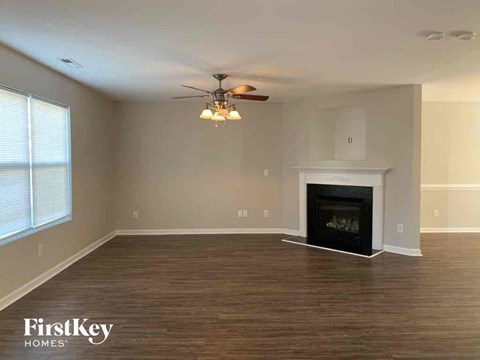 a living room with a fireplace and a ceiling fan