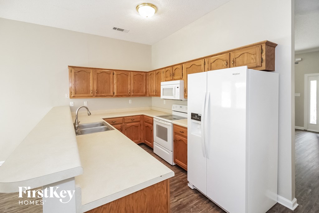 a kitchen with white appliances and wooden cabinets