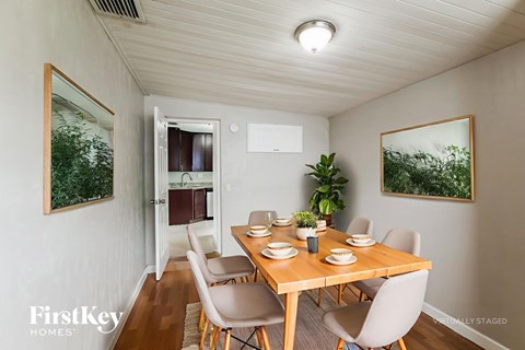 A dining room with a wooden table and chairs.