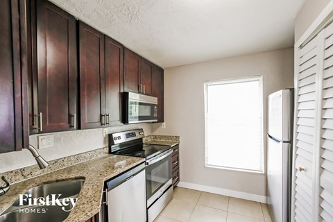 A kitchen with brown cabinets and a white refrigerator.