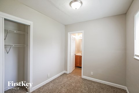 A bedroom with a carpeted floor and a small closet.