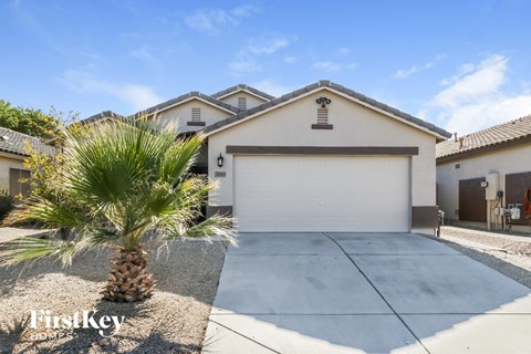 a house with a garage and a palm tree in front of it