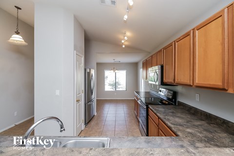 a kitchen with granite countertops and wooden cabinets and stainless steel appliances