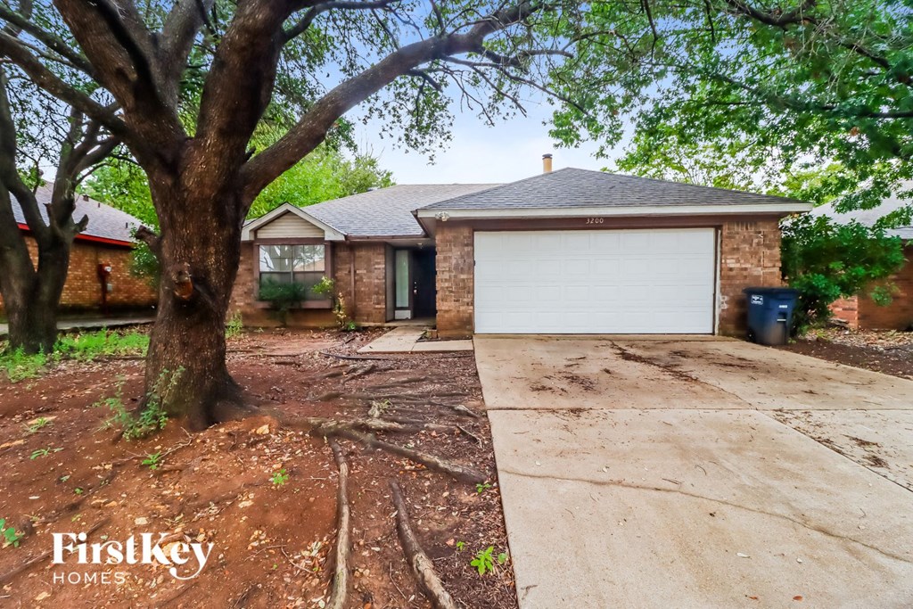 a small brick house with a driveway and a garage door
