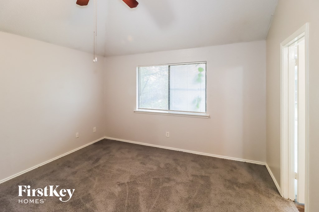 a bedroom with a carpeted floor and a window