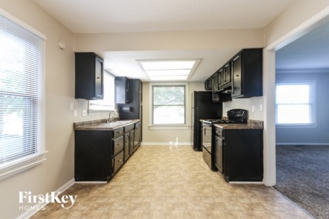 A kitchen with black appliances and cabinets is shown.