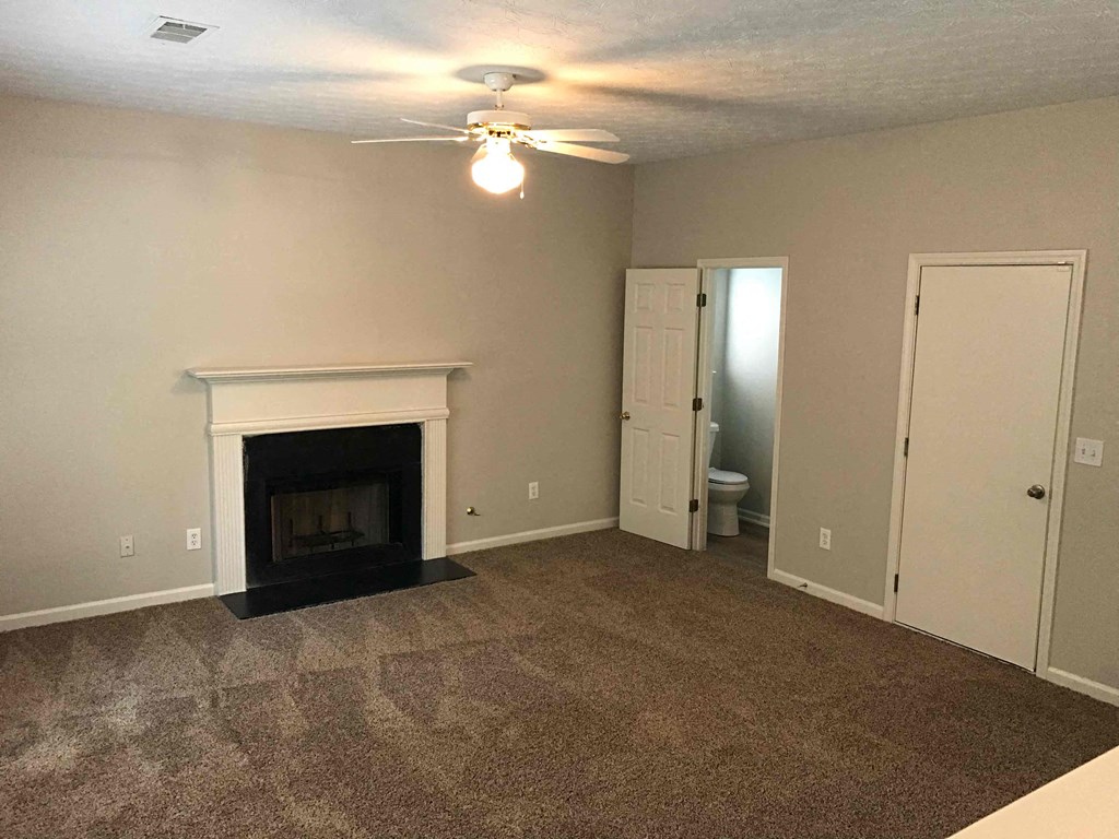 a living room with a fireplace and a ceiling fan