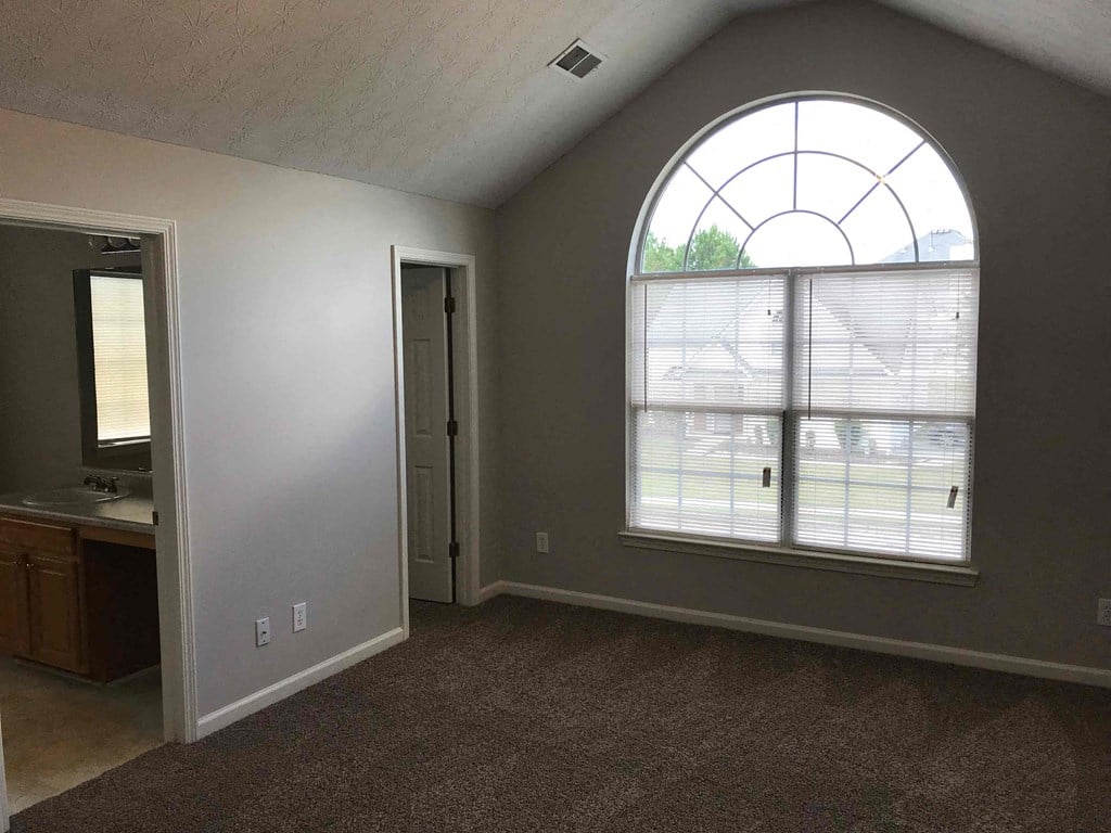 an empty living room with a large window and a sink