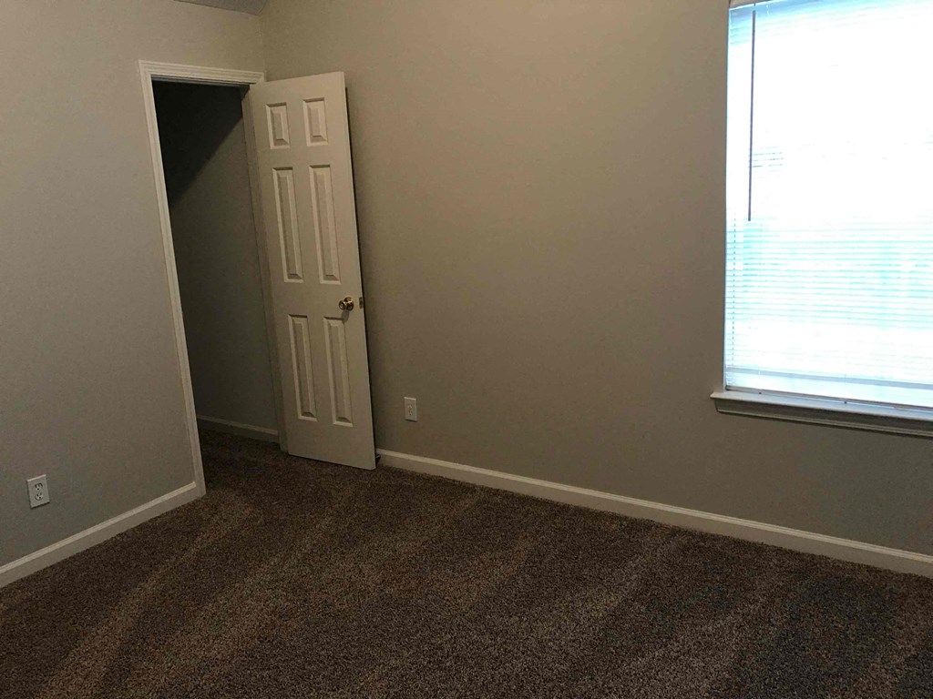 a room with a door and a window and a carpeted floor