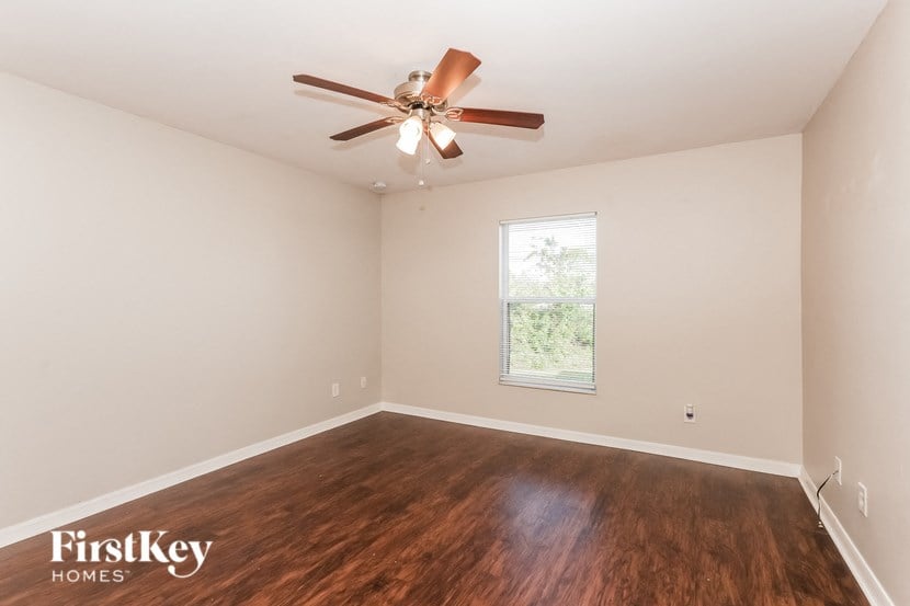 a bedroom with hardwood flooring and a ceiling fan
