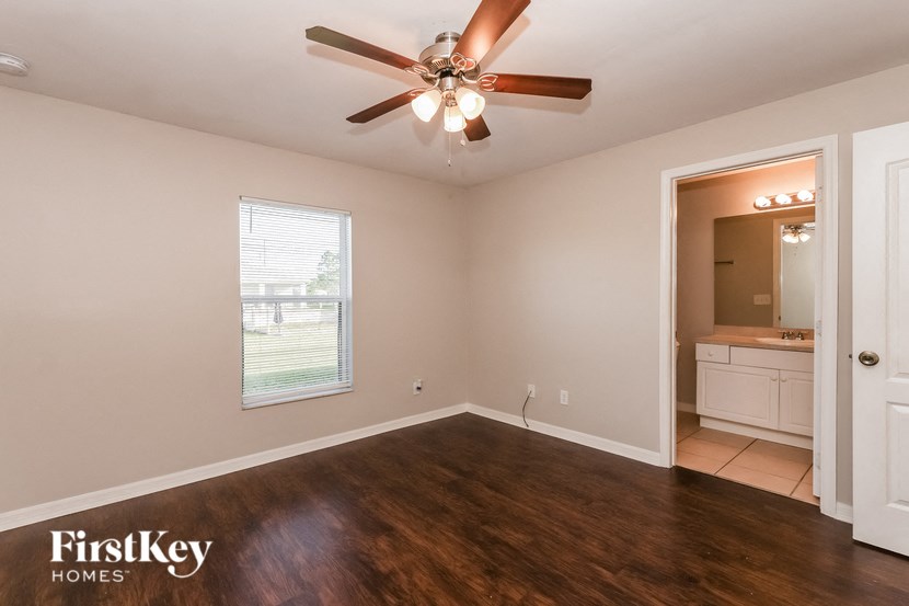 the living room of an empty house with a ceiling fan