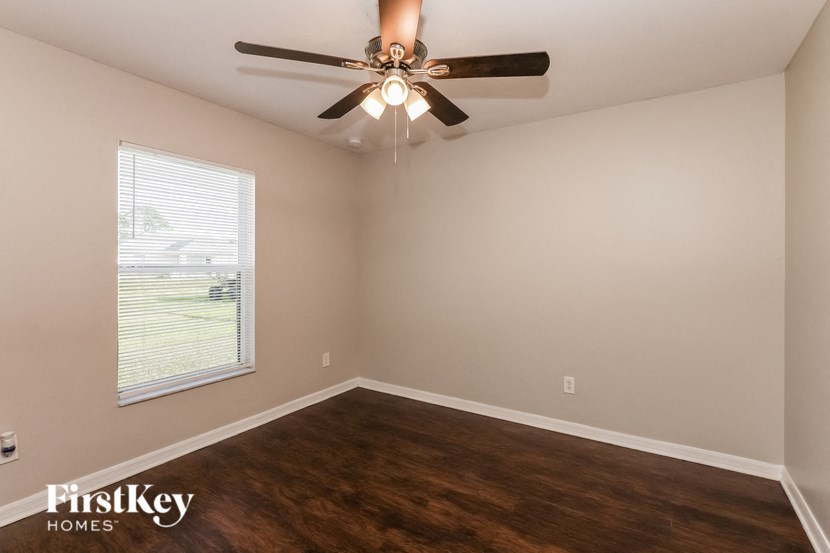 a bedroom with a ceiling fan and a window