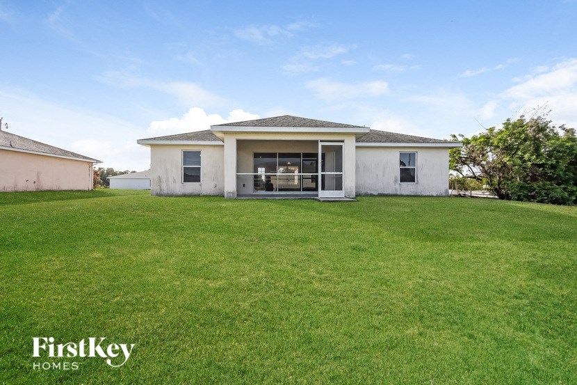 a small white house with a lawn and a patio