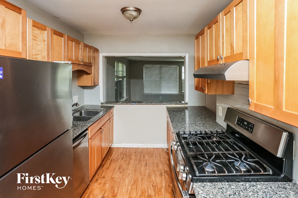 a kitchen with wood cabinets and stainless steel appliances and granite counter tops