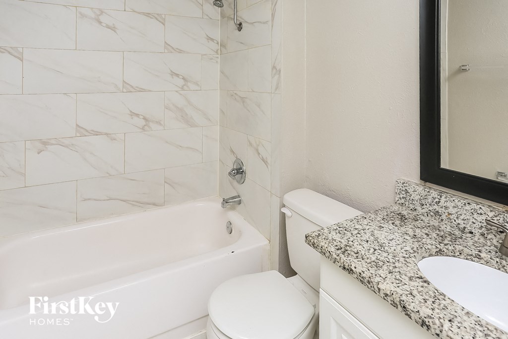 a bathroom with a tub and a sink and a toilet