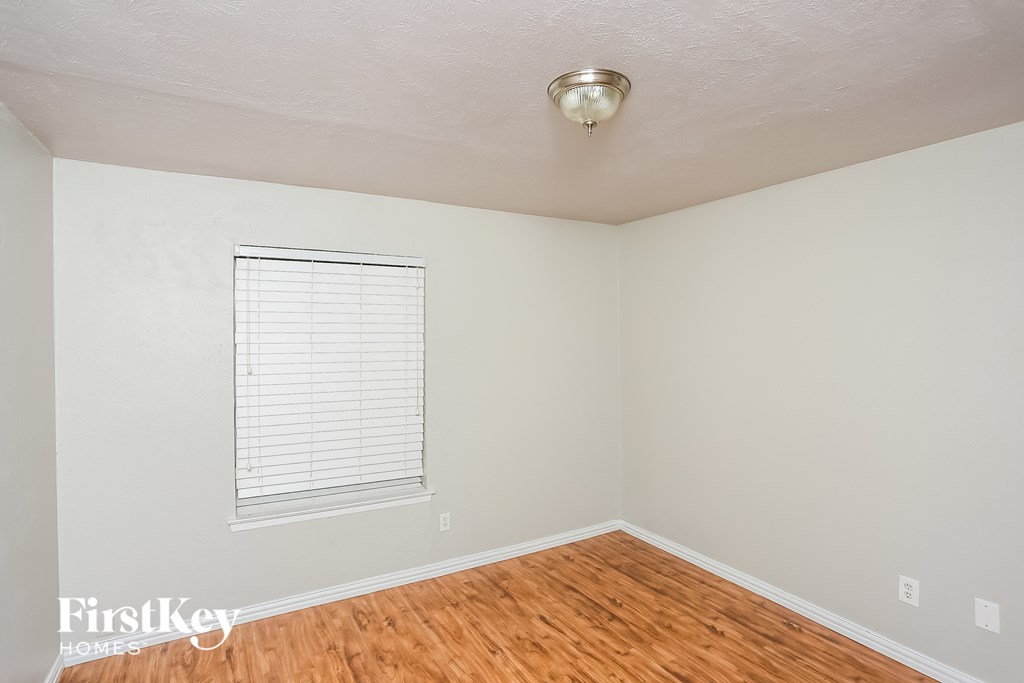 the living room of an empty house with wood floors and a window
