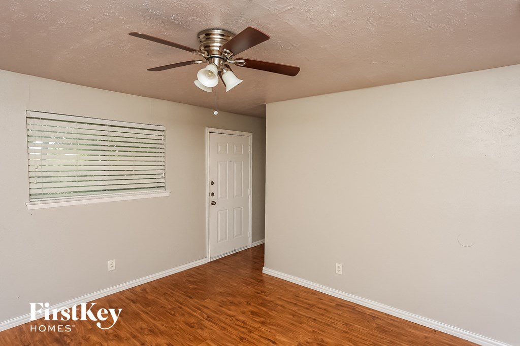 the living room of an empty house with a ceiling fan