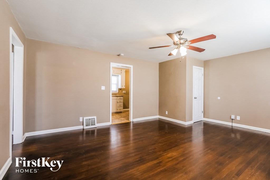 a living room with wood floors and a ceiling fan