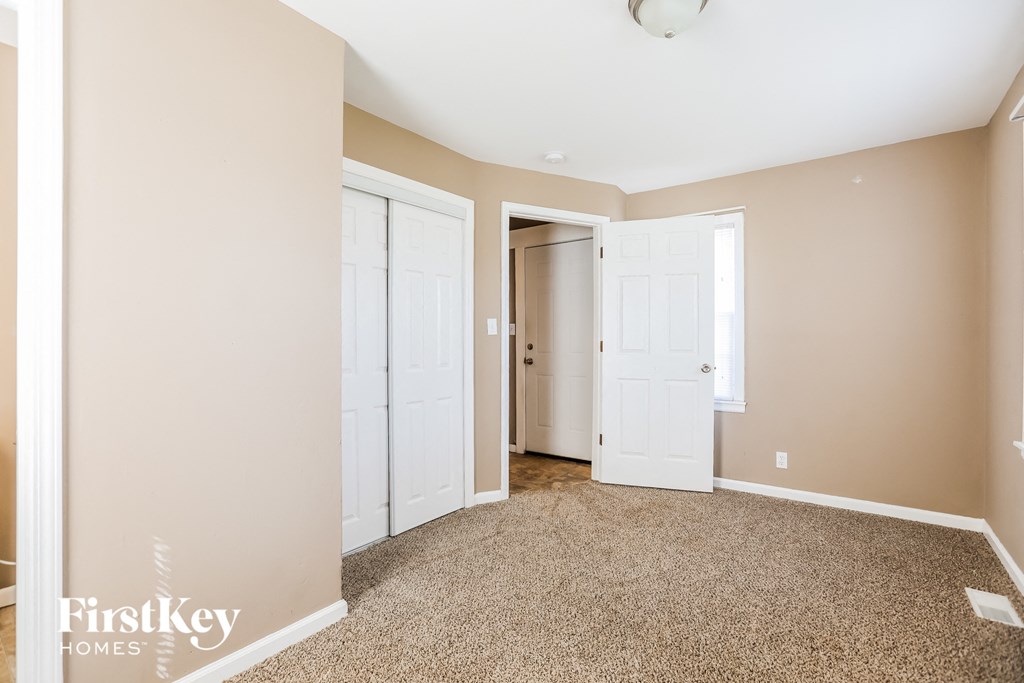 a master bedroom with two closets and a carpeted floor