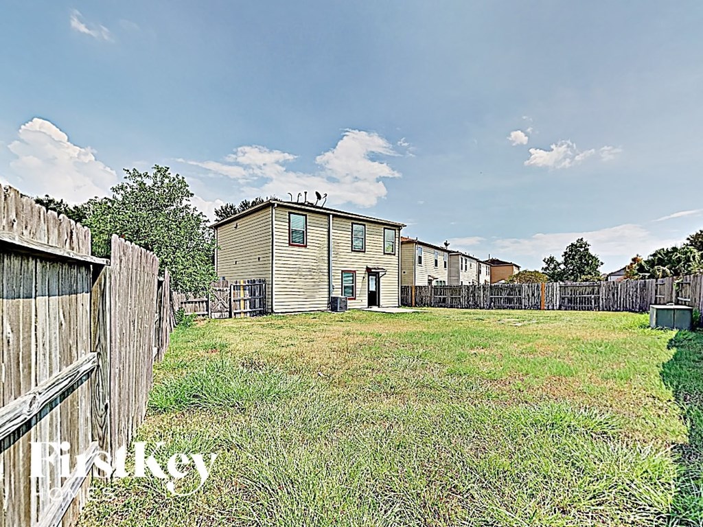 the backyard of a house with a yard and a wooden fence