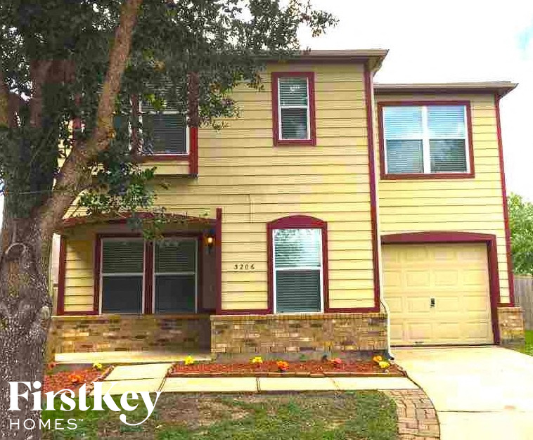 a yellow house with a tree in front of it