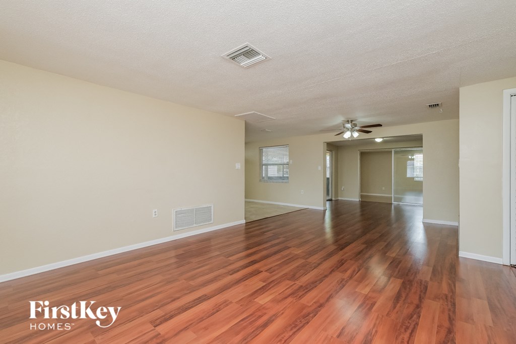 A room with wooden floors and a ceiling fan.