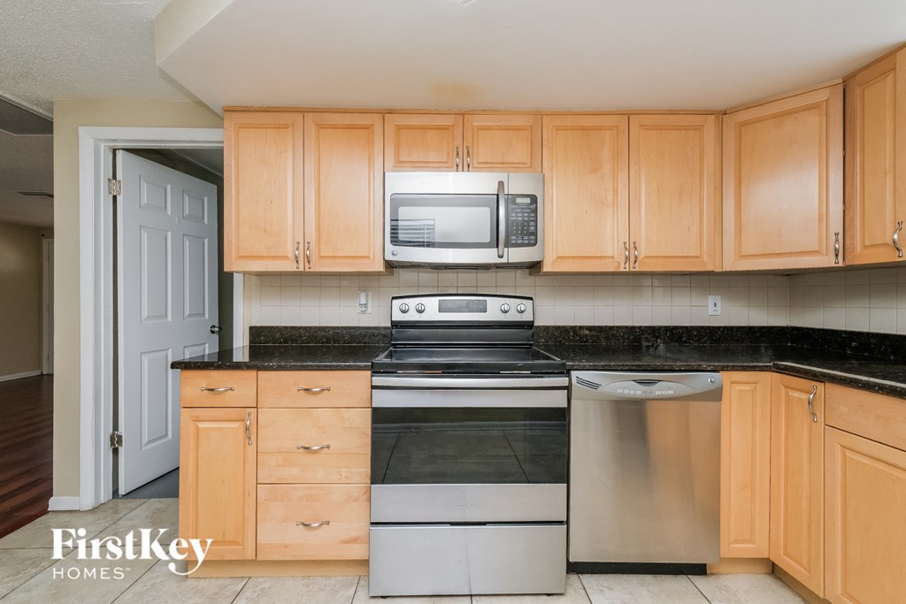 A kitchen with wooden cabinets and a stainless steel dishwasher.