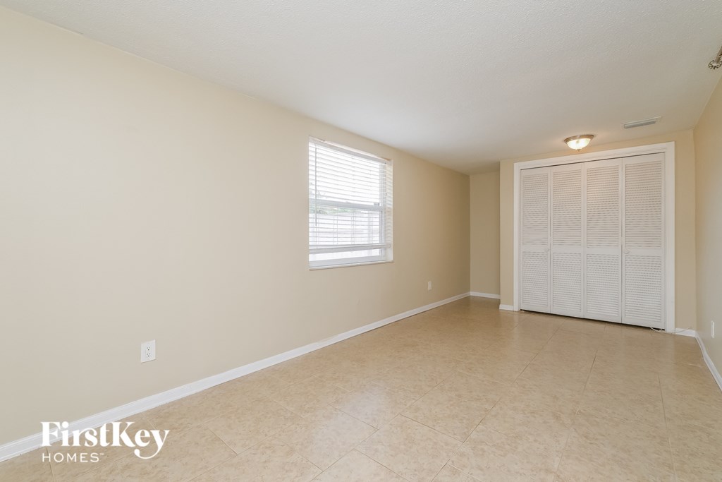 A room with a window and a door is empty and waiting to be furnished.