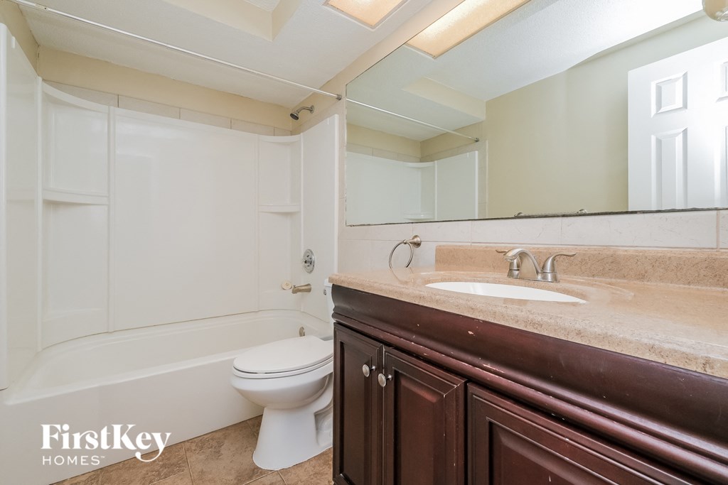 A white toilet sits in a bathroom with brown cabinetry.