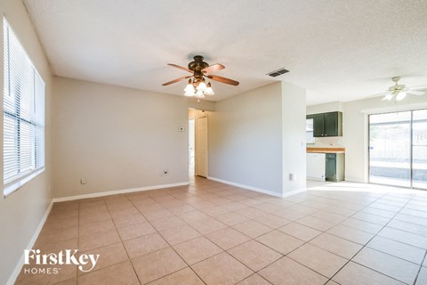 A spacious room with a ceiling fan and tiled floor.