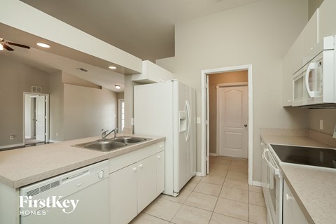 a kitchen with white cabinets and a sink and a refrigerator