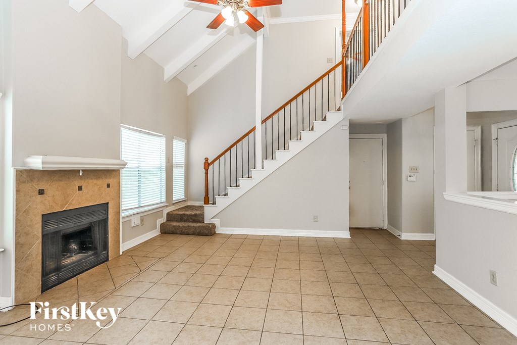 an empty living room with a fireplace and a staircase