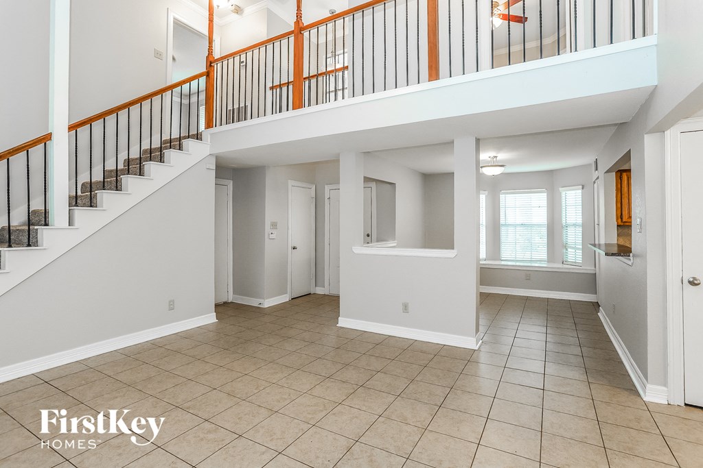an empty living room with a staircase in a house
