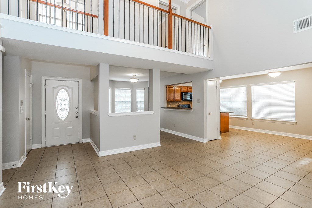 the entryway of a house with a white door and a balcony