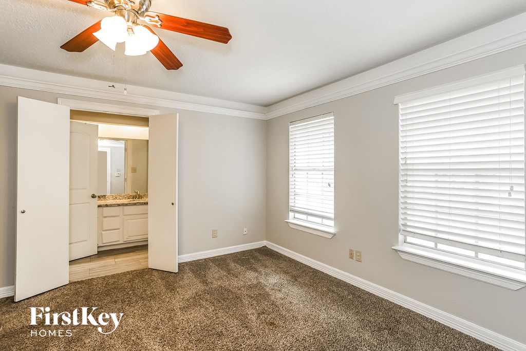 a bedroom with a carpeted floor and a ceiling fan