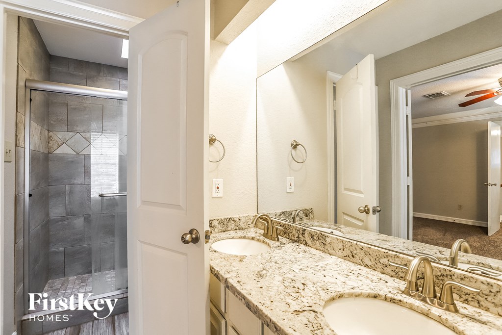 a bathroom with two sinks and a mirror and a shower