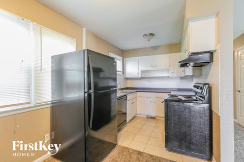A kitchen with a black refrigerator and a black dishwasher.