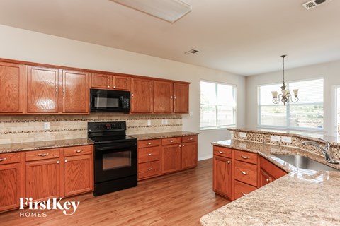 A kitchen with wooden cabinets and a black oven.
