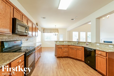 A kitchen with wooden cabinets and a FirstKey Homes logo.