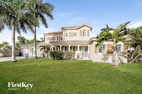 a large house with palm trees in front of it